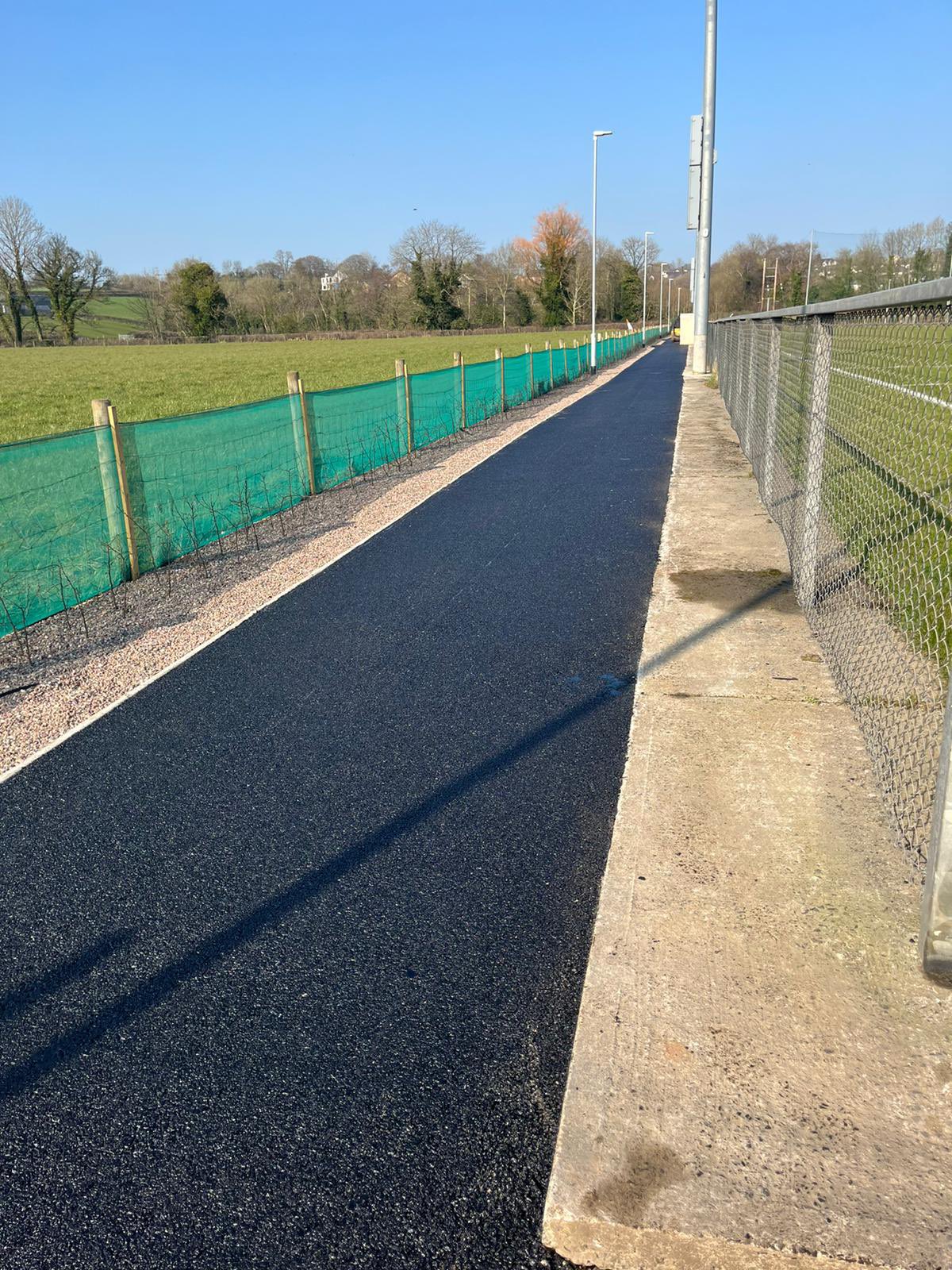 Tarmac pathway alongside football pitch
