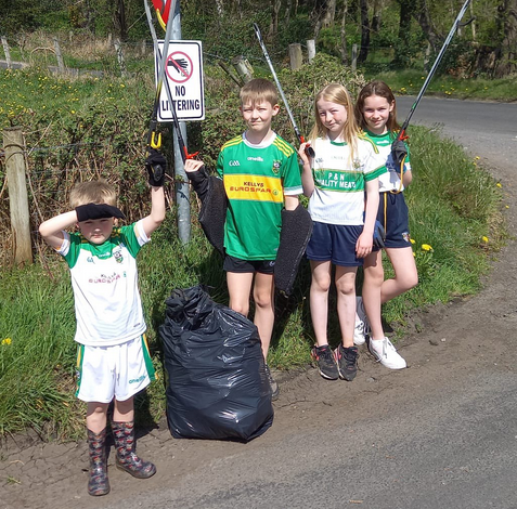 boys and girls beside collected rubbish on country road
