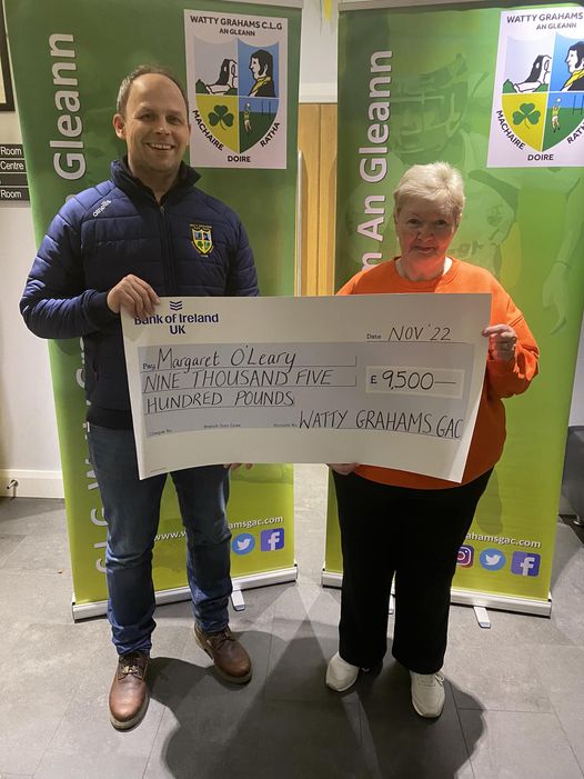 Barry presenting Margaret with the winning lotto cheque of £9500